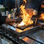Een goed georganiseerde horeca keuken met essentiële apparatuur zoals koeltoonbanken en espressomachines.