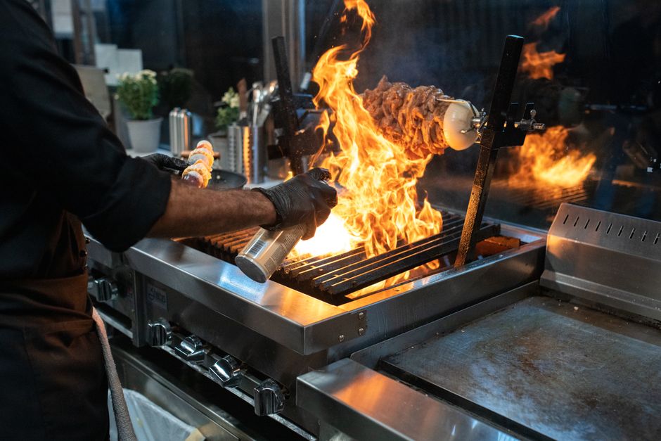 Een goed georganiseerde horeca keuken met essentiële apparatuur zoals koeltoonbanken en espressomachines.