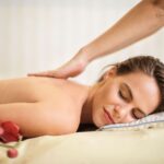 Een persoon die ontspannen ligt met een massagekussen voor betere slaapkwaliteit.
