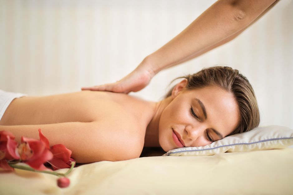 Een persoon die ontspannen ligt met een massagekussen voor betere slaapkwaliteit.
